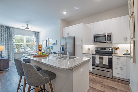 a kitchen with white cabinets and a marble counter top